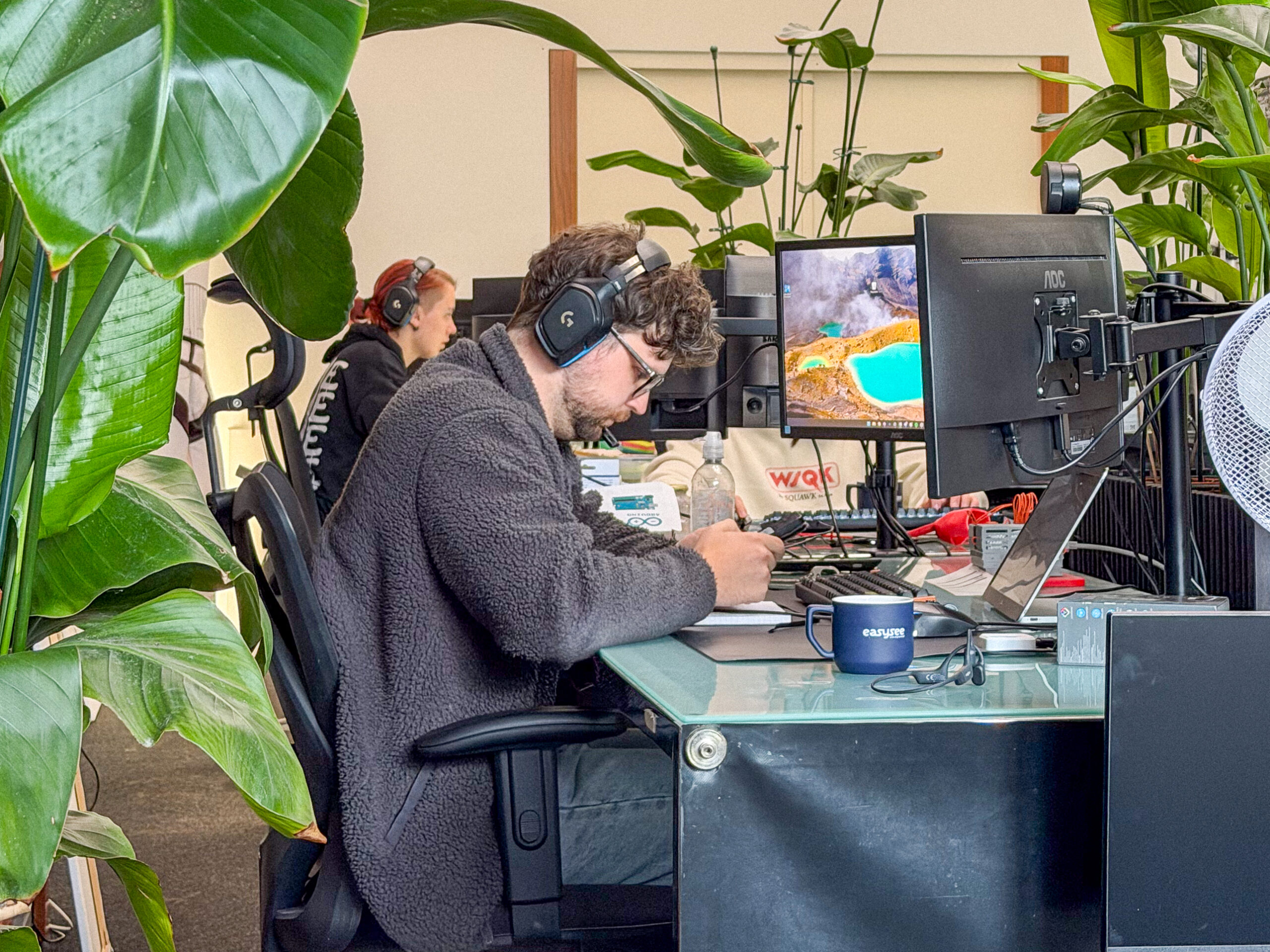 A developer wearing headphones focused on coding a custom workflow tool during the Tooling Day sprint.
