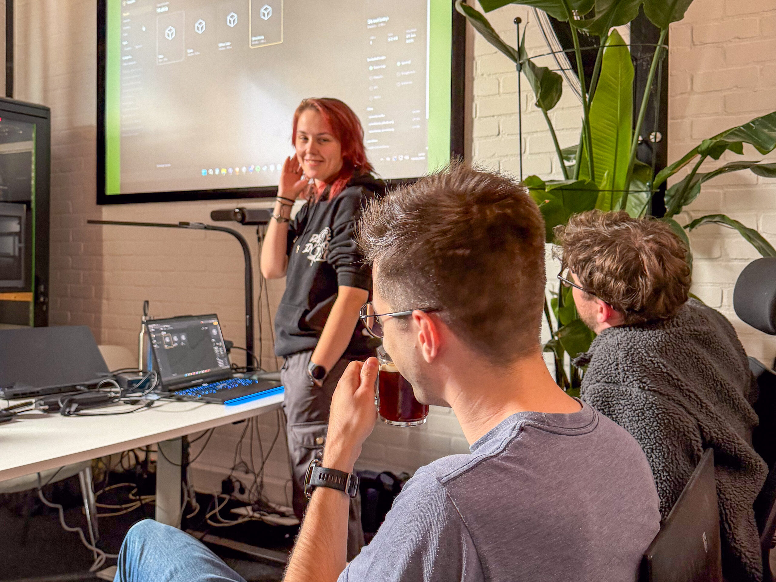 A team member presenting the interface of a new prototype on the big screen during the Tooling Day check-in.